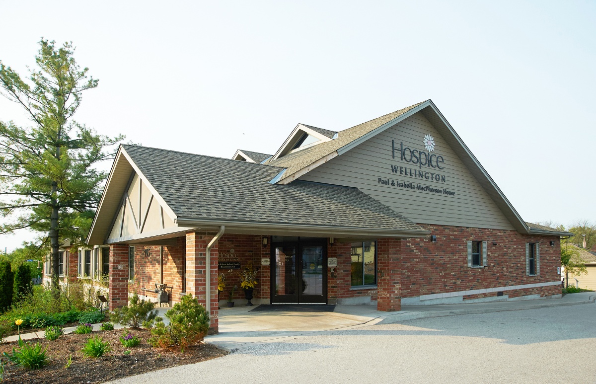 Dhisme leben ah oo leh calaamadda &quot;Hospice Wellington&quot; ee ka sarreysa albaabka laga soo galo maalin cad.