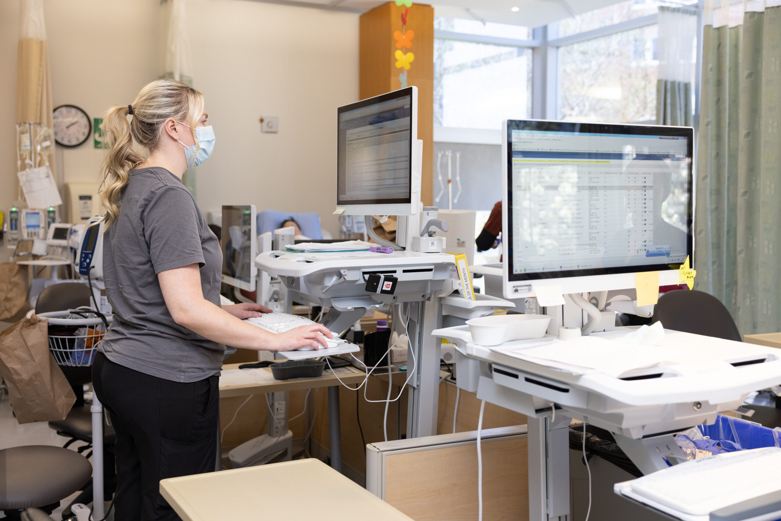 Nurse viewing a computer while monitoring patients in the Systemic Suite