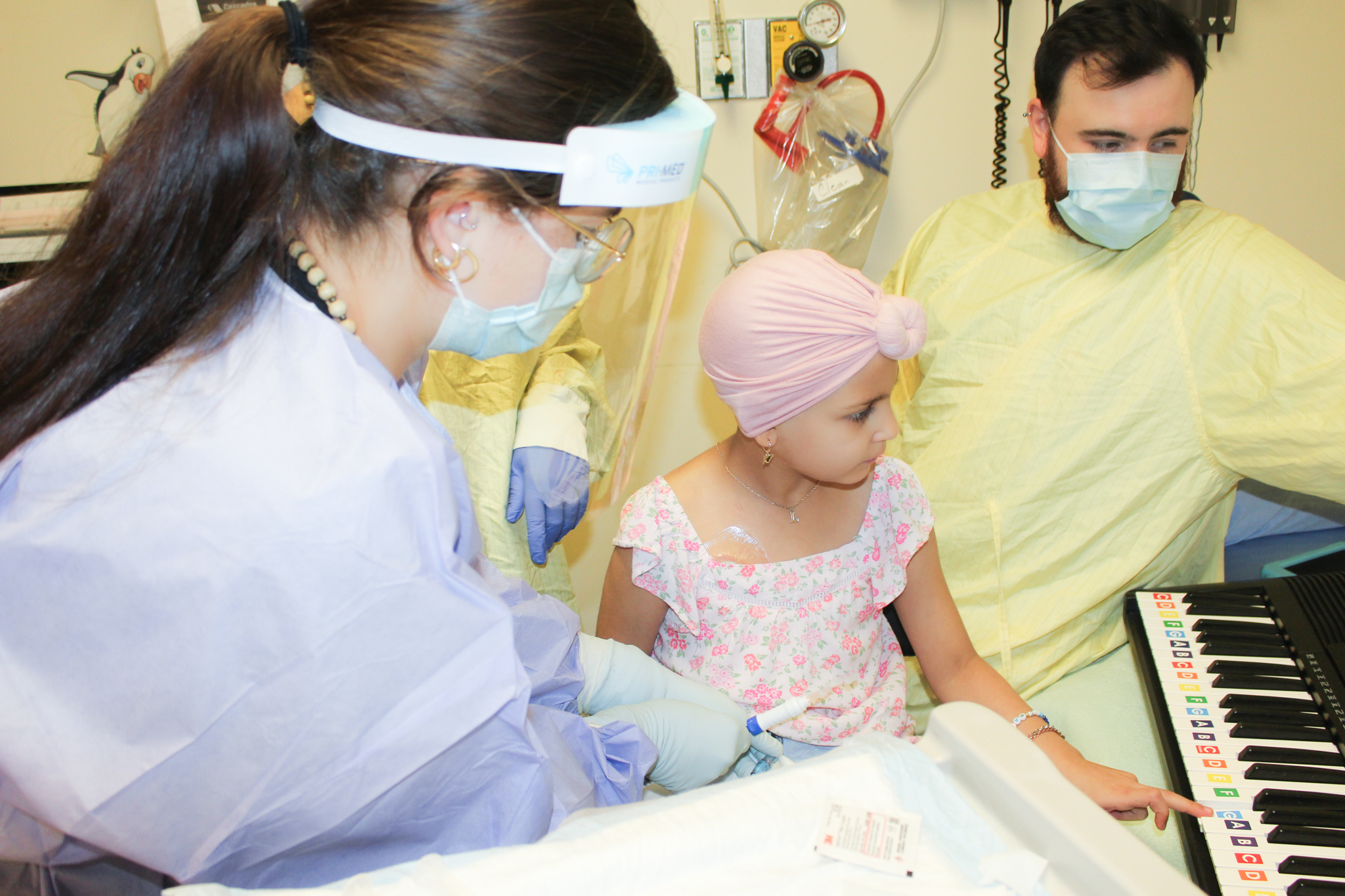Two healthcare workers with child cancer patient.